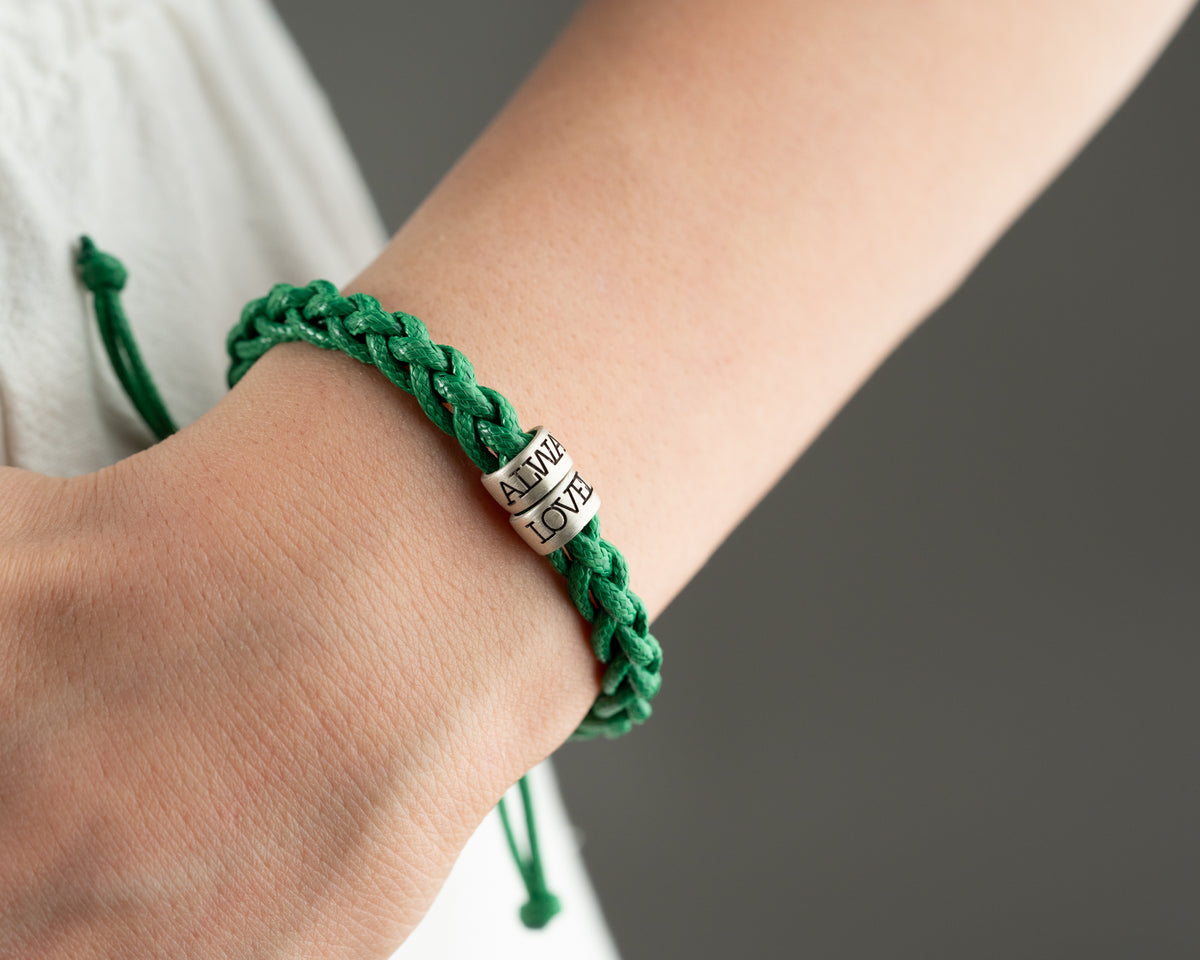 Women's hand-braided bracelet with personalized charms, crafted in the Artizian studio