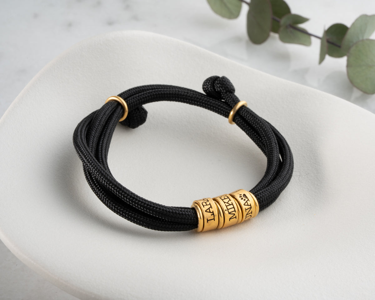 Men's paracord bracelet with personalized engraved beads, crafted in the Artizian studio
